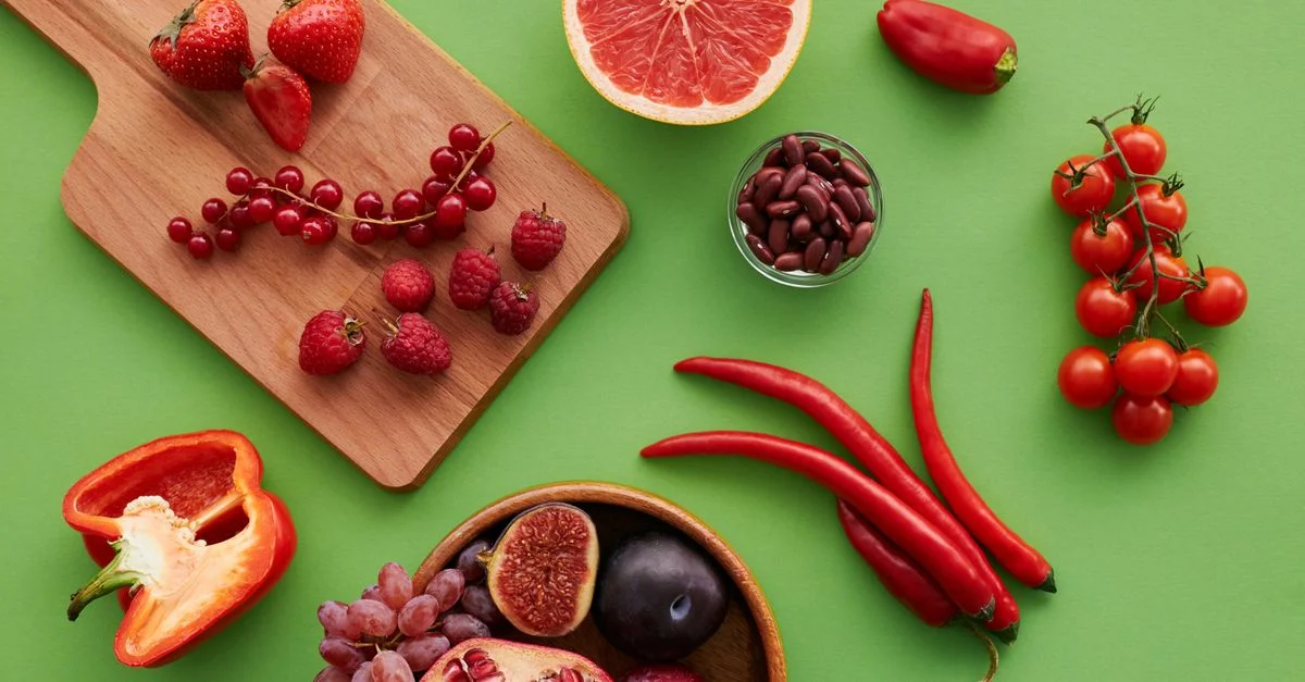 Vue de dessus d'une sélection vibrante de fruits et de légumes sur fond vert.