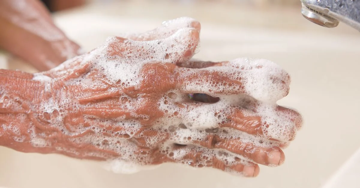 Un tirage détaillé de mains couvertes de mousse de savon, mettant en avant l'hygiène et la propreté.
